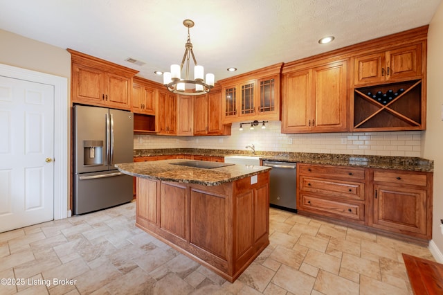 2990 Cedar Grove Rd, Shepherdsville, KY 40165 - kitchen featuring appliances with stainless steel finishes, a chandelier, brown cabinets, stone finish flooring, and dark stone countertops