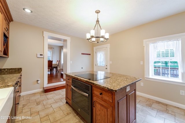 2990 Cedar Grove Rd, Shepherdsville, KY 40165 - kitchen featuring black appliances, brown cabinets, a chandelier, hanging light fixtures, and light stone finish flooring