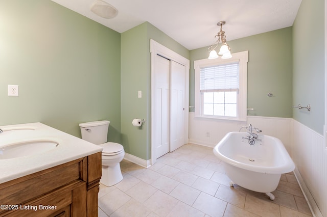 2990 Cedar Grove Rd, Shepherdsville, KY 40165 - bathroom featuring a soaking tub, double vanity, a wainscoted wall, and tile patterned floors