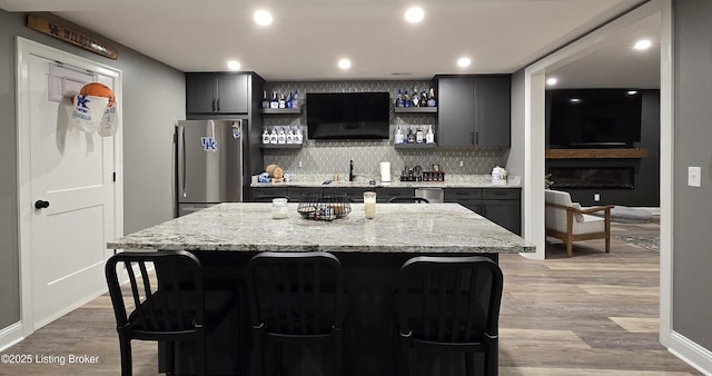 6015 St Bernadette Ave, Prospect, KY 40059 - indoor wet bar featuring stainless steel appliances, decorative backsplash, light wood-style floors, and recessed lighting