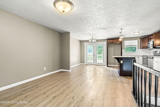 3619 Endeavor Way, Louisville, KY 40219 - kitchen featuring stainless steel microwave, range, light wood-style flooring, light countertops, and a textured ceiling