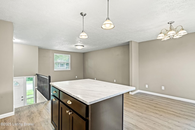 3619 Endeavor Way, Louisville, KY 40219 - kitchen featuring light wood finished floors, a textured ceiling, dark brown cabinets, a chandelier, and pendant lighting