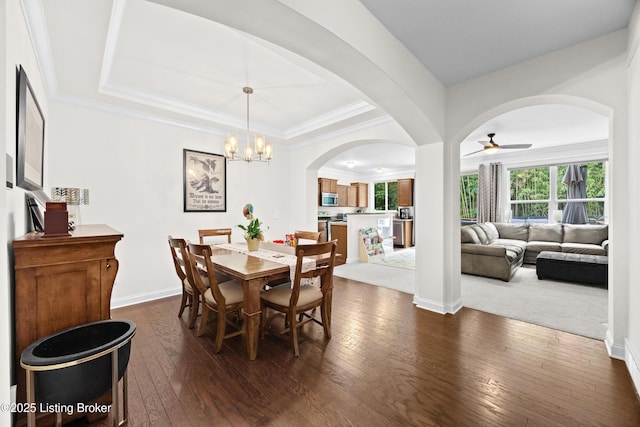 13420 Cain Ln, Louisville, KY 40245 - dining area with dark wood-style flooring, a chandelier, a ceiling fan, arched walkways, and a raised ceiling