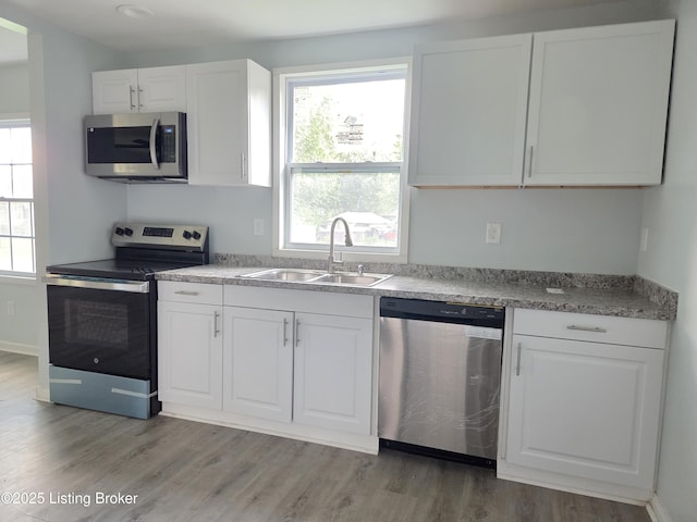 342 E Southside Ct, Louisville, KY 40214 - kitchen featuring appliances with stainless steel finishes, white cabinets, light wood finished floors, and light countertops