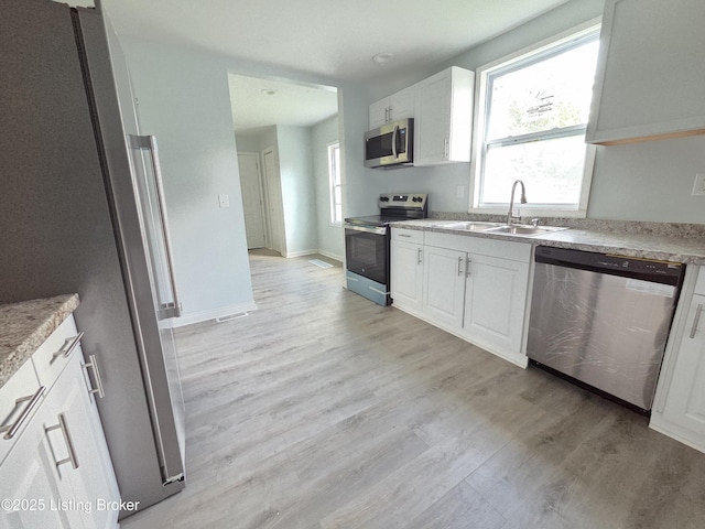 342 E Southside Ct, Louisville, KY 40214 - kitchen featuring stainless steel appliances, light wood finished floors, white cabinetry, and light countertops