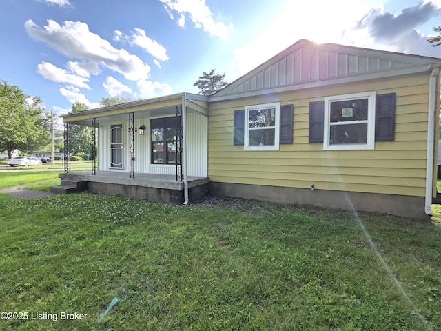 342 E Southside Ct, Louisville, KY 40214 - view of front of home with a porch, a front lawn, and board and batten siding