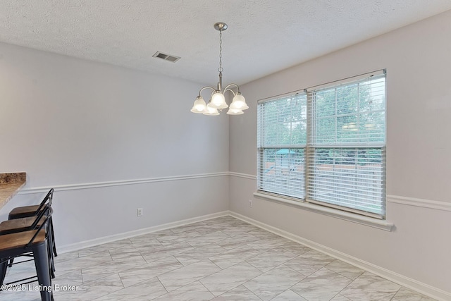 152 Glen Ridge Dr, Mt Washington, KY 40047 - unfurnished dining area with light marble finish flooring, a chandelier, and a textured ceiling