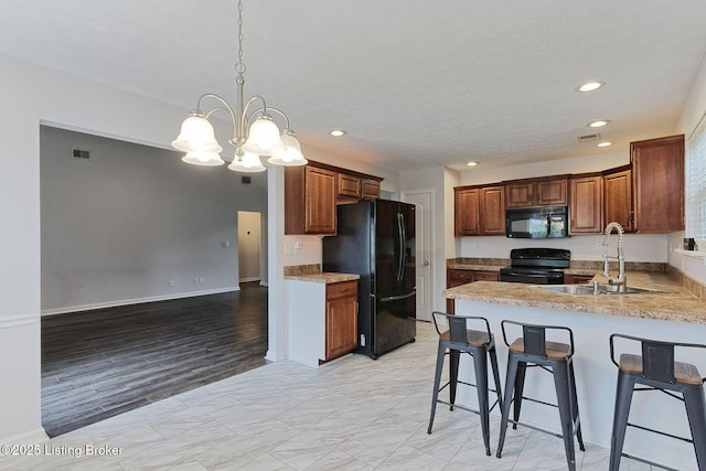 152 Glen Ridge Dr, Mt Washington, KY 40047 - kitchen featuring black appliances, a peninsula, a breakfast bar, a chandelier, and recessed lighting