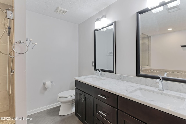 152 Glen Ridge Dr, Mt Washington, KY 40047 - bathroom with double vanity, tile patterned flooring, a textured ceiling, a tile shower, and recessed lighting