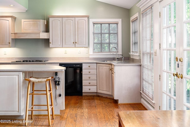 3920 Elfin Ave, Louisville, KY 40207 - kitchen featuring black dishwasher, vaulted ceiling, light countertops, light wood finished floors, and a breakfast bar