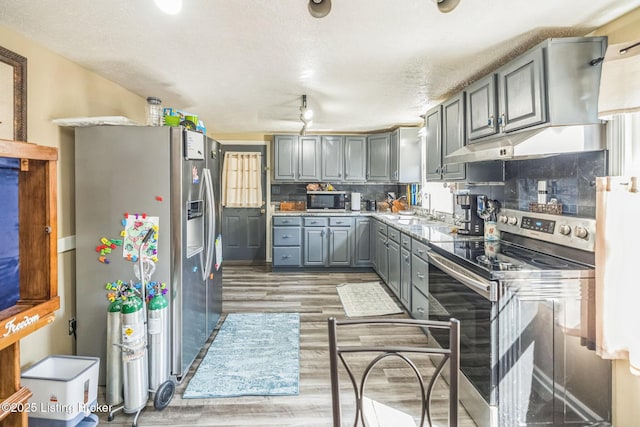 917 Scaffold Cane Rd, Berea, KY 40403 - kitchen with stainless steel appliances, gray cabinetry, light wood-style floors, under cabinet range hood, and backsplash