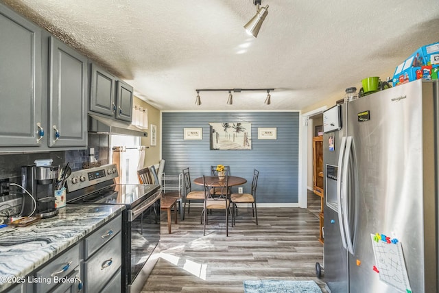917 Scaffold Cane Rd, Berea, KY 40403 - kitchen featuring appliances with stainless steel finishes, a textured ceiling, track lighting, wood finished floors, and under cabinet range hood
