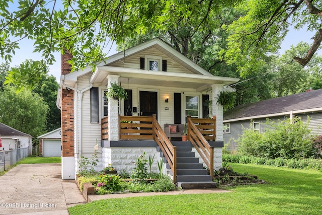 1248 Springdale Dr, Louisville, KY 40213 - view of front of property featuring covered porch, a front yard, a chimney, an outdoor structure, and a detached garage