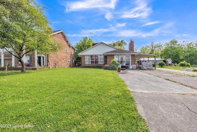911 N Main St, Barbourville, KY 40906 - view of front of home with brick siding, driveway, a carport, and a front yard