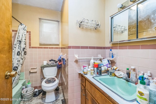 911 N Main St, Barbourville, KY 40906 - bathroom with tile walls, vanity, shower / bath combo with shower curtain, and wainscoting