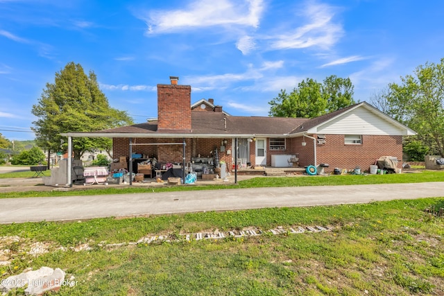 911 N Main St, Barbourville, KY 40906 - rear view of house featuring a chimney, brick siding, and a lawn