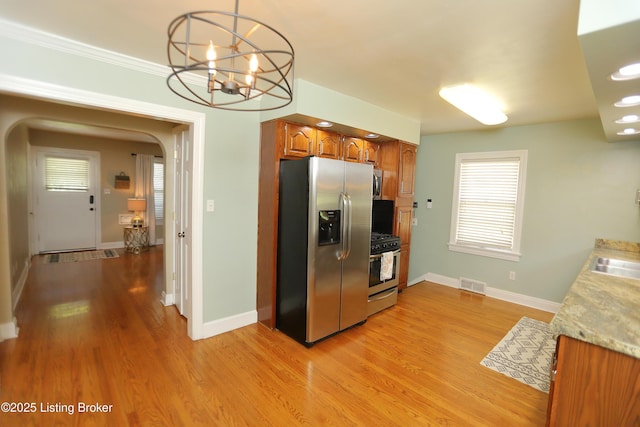 3303 Eagle Pass, Louisville, KY 40213 - kitchen featuring appliances with stainless steel finishes, arched walkways, brown cabinets, and light wood finished floors