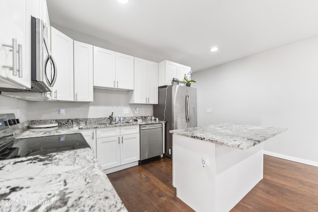 930 York St, Newport, KY 41071 - kitchen with appliances with stainless steel finishes, recessed lighting, dark wood-style floors, white cabinets, and light stone counters