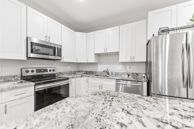 930 York St, Newport, KY 41071 - kitchen featuring appliances with stainless steel finishes, white cabinetry, and light stone countertops
