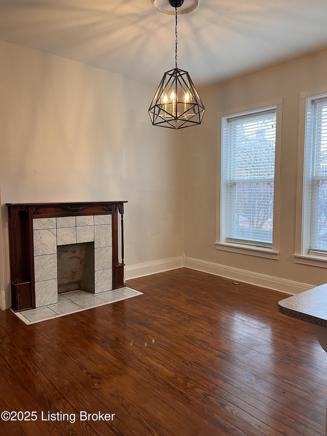 1308 S 2nd St, Louisville, KY 40208 - unfurnished living room featuring wood-type flooring, a chandelier, and a tiled fireplace