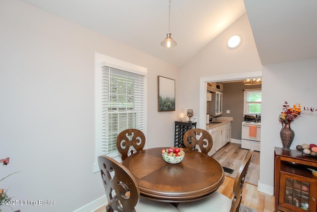 129 E Park Pl, Jeffersonville, IN 47130 - dining area featuring light wood-style flooring, vaulted ceiling, and a chandelier