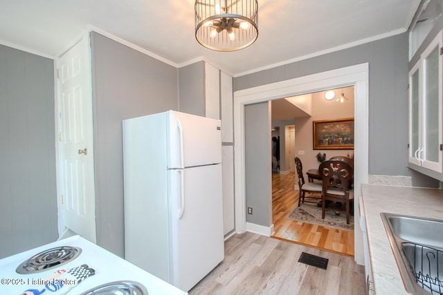 129 E Park Pl, Jeffersonville, IN 47130 - kitchen with freestanding refrigerator, light wood-style floors, a chandelier, crown molding, and light countertops