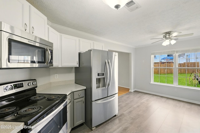 11411 Catalpa View Ct, Louisville, KY 40299 - kitchen featuring appliances with stainless steel finishes, light countertops, white cabinetry, a textured ceiling, and ornamental molding