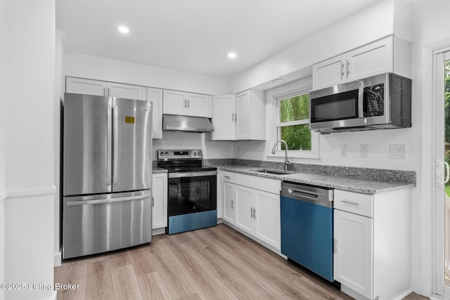 4900 Glenna Way, Louisville, KY 40219 - kitchen with appliances with stainless steel finishes, under cabinet range hood, white cabinetry, light stone countertops, and light wood-style floors