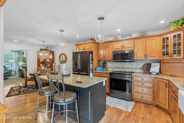 1119 Skyview Dr, Carrollton, KY 41008 - kitchen with black fridge with ice dispenser, electric stove, light wood-type flooring, light stone countertops, and recessed lighting