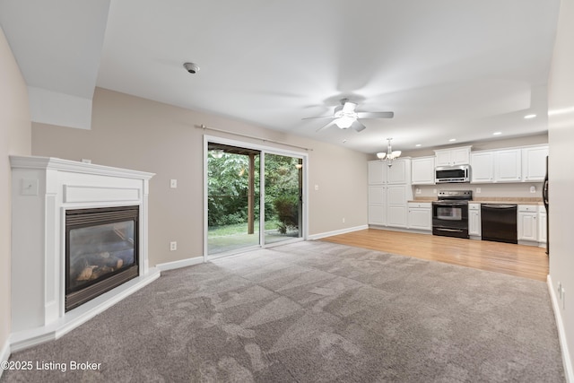 751 N Hite Ave Unit 2, Louisville, KY 40206 - unfurnished living room featuring light carpet, ceiling fan, a glass covered fireplace, recessed lighting, and a chandelier