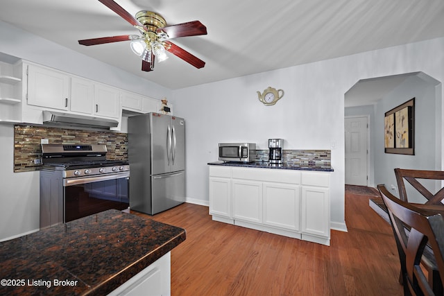 2301 Farnsley Rd, Louisville, KY 40216 - kitchen with appliances with stainless steel finishes, under cabinet range hood, open shelves, dark countertops, and decorative backsplash