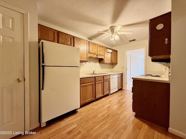 1305 Donard Park Ave, Louisville, KY 40218 - kitchen featuring white appliances, a ceiling fan, light wood finished floors, light countertops, and a textured ceiling