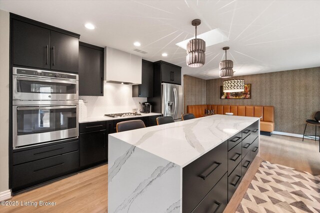 1430 Oakmont Ct, Shelbyville, KY 40065 - kitchen featuring dark cabinets, stainless steel appliances, light wood-style floors, wallpapered walls, and pendant lighting