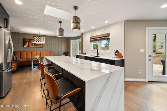 1430 Oakmont Ct, Shelbyville, KY 40065 - kitchen featuring stainless steel fridge, light wood finished floors, recessed lighting, a kitchen island, and a kitchen breakfast bar