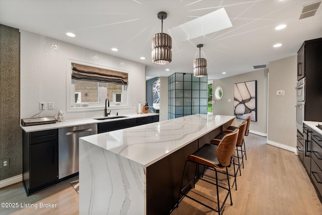 1430 Oakmont Ct, Shelbyville, KY 40065 - kitchen featuring stainless steel appliances, a kitchen island, light wood-style flooring, dark cabinetry, and a breakfast bar