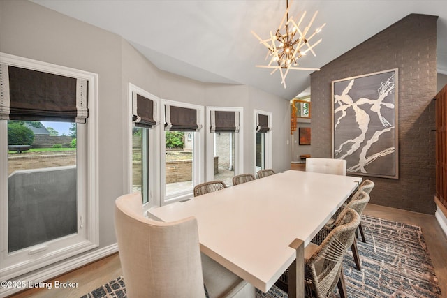 1430 Oakmont Ct, Shelbyville, KY 40065 - dining room with wood finished floors, a chandelier, plenty of natural light, vaulted ceiling, and brick wall