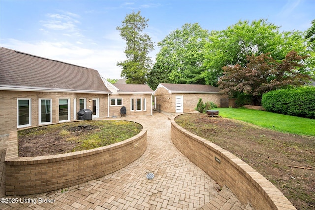 1430 Oakmont Ct, Shelbyville, KY 40065 - view of front of house featuring a patio area, roof with shingles, an outbuilding, and brick siding