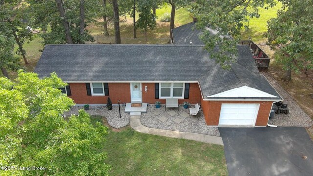 933 Lakeshore Pkwy, Brandenburg, KY 40108 - view of front of house featuring a garage, brick siding, driveway, and roof with shingles