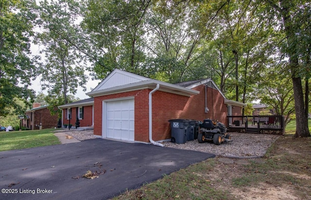 933 Lakeshore Pkwy, Brandenburg, KY 40108 - view of side of property featuring a garage, a wooden deck, asphalt driveway, and brick siding