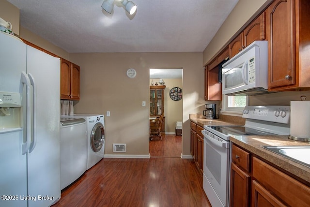 933 Lakeshore Pkwy, Brandenburg, KY 40108 - kitchen with white appliances, washer and dryer, brown cabinetry, and dark wood-style flooring