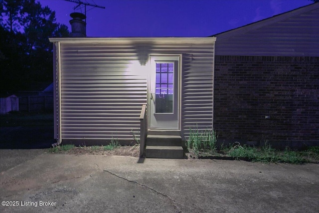 5709 Midnight Ln, Louisville, KY 40229 - exterior entry at twilight with a chimney and brick siding