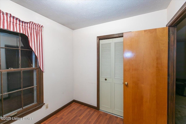 5709 Midnight Ln, Louisville, KY 40229 - unfurnished bedroom featuring dark wood-type flooring, a closet, and a textured ceiling