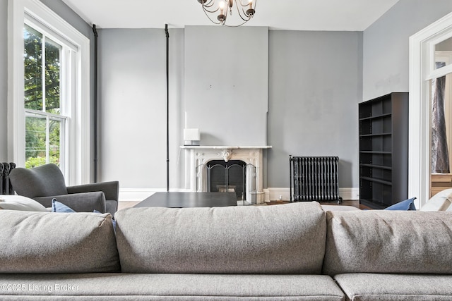 1080 Baxter Ave Unit 2, Louisville, KY 40204 - living room featuring radiator heating unit, a fireplace, healthy amount of natural light, and a chandelier