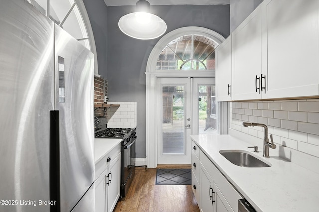 1080 Baxter Ave Unit 2, Louisville, KY 40204 - kitchen featuring freestanding refrigerator, black gas range oven, backsplash, white cabinets, and dark wood-type flooring