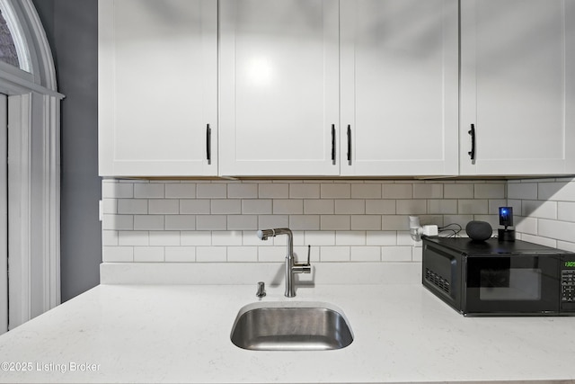 1080 Baxter Ave Unit 2, Louisville, KY 40204 - kitchen with black microwave, white cabinets, tasteful backsplash, and light stone countertops
