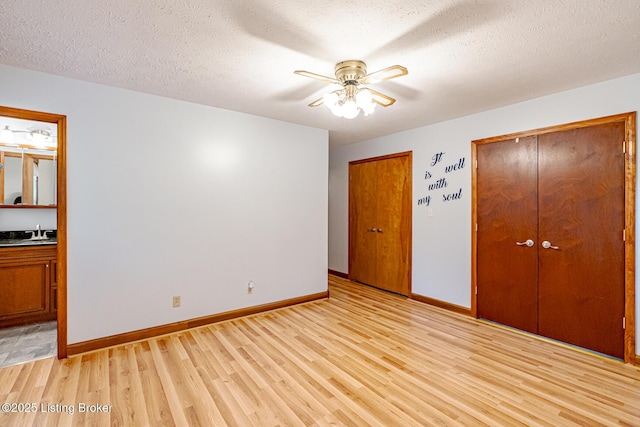 520 Ponder Dr, Shelbyville, KY 40065 - unfurnished bedroom featuring light wood-type flooring, two closets, ensuite bath, a textured ceiling, and a ceiling fan