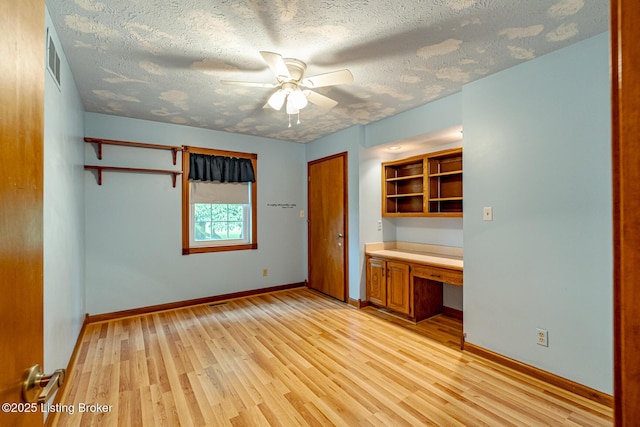 520 Ponder Dr, Shelbyville, KY 40065 - unfurnished bedroom with built in desk, light wood-style floors, a textured ceiling, a closet, and ceiling fan