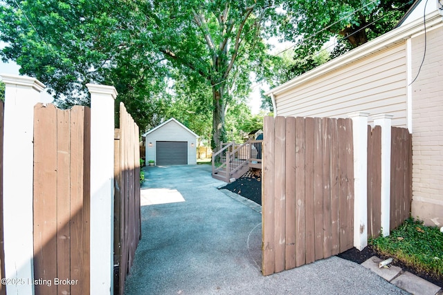 4025 Elmwood Ave, Louisville, KY 40207 - view of patio / terrace with asphalt driveway, an outdoor structure, and a garage