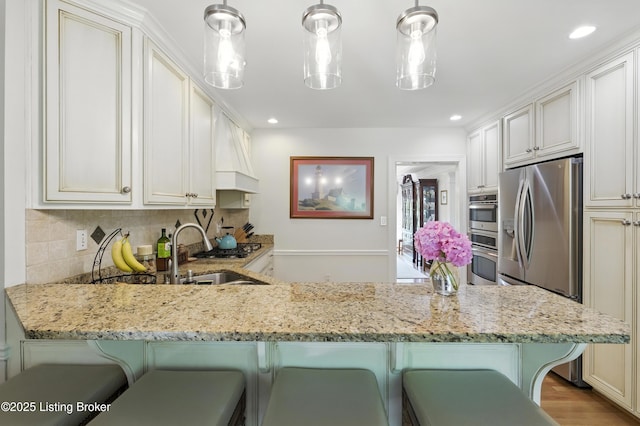 1375 Waxwing Pl, Louisville, KY 40223 - kitchen with a peninsula, light stone countertops, decorative backsplash, stainless steel appliances, and recessed lighting