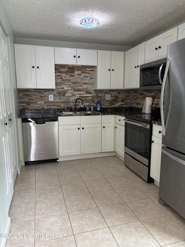 11902 Queen Annes Ct, Louisville, KY 40245 - kitchen featuring appliances with stainless steel finishes, decorative backsplash, a textured ceiling, white cabinets, and light tile patterned floors